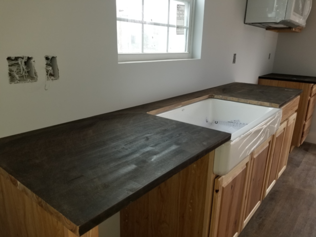 butchers block countertops with wood cabinets and custom white built in sink