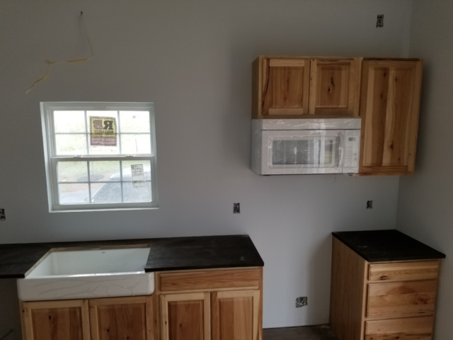 half finished kitchen new construction with oak cabinets and butchers block countertops