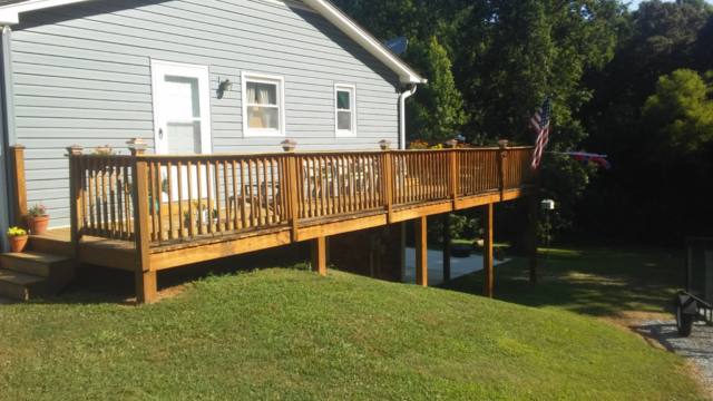 finished wooden treated deck with golden stain and new handrails