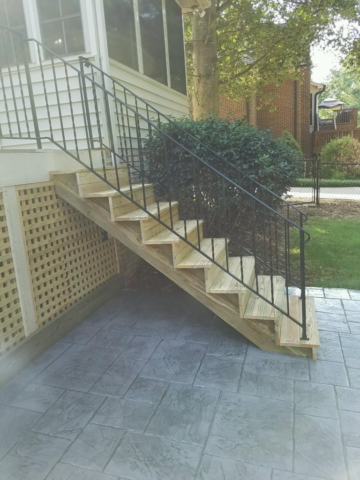 wooden staircase with black iron handrails