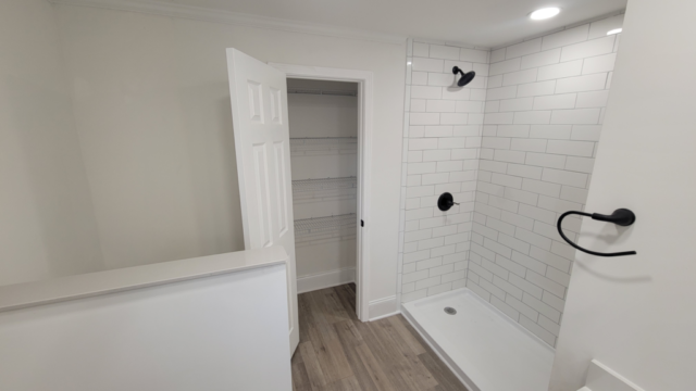 custom renovation interior bathroom white tile white walls black hardware fixtures