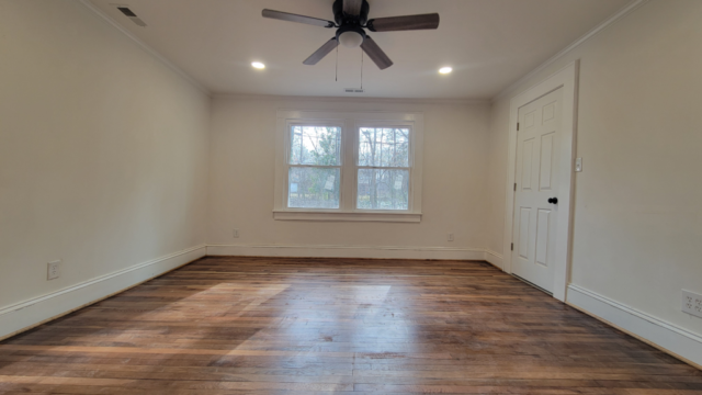 bedroom remodel with white trim and red hardwood floors
