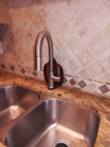 Kitchen Faucet Installed in front of backsplash neutral tile stainless steel kitchen faucet