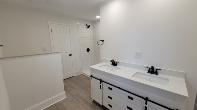 finished master bathroom white tile shower black hardware and fixtures