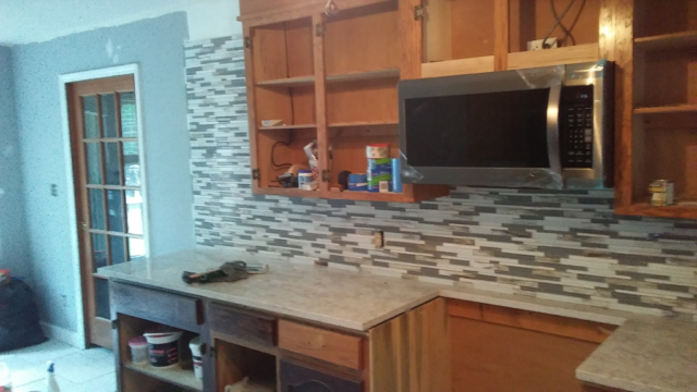 pencil tile backsplash white and gray tile with wood cabinets half finished